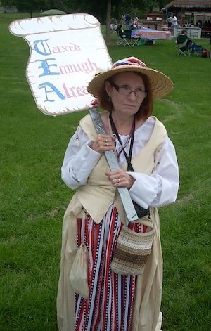 A woman holds a sign reading Taxed Enough Already.