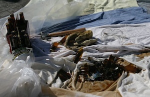 Smashed beer bottles with the mess contained in a p.astic lined sheet.
