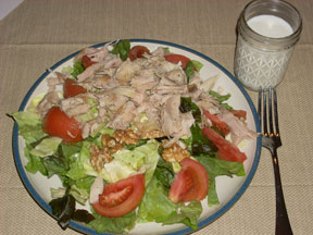 Salad with tomato, turkey, walnuts, and olive oil..