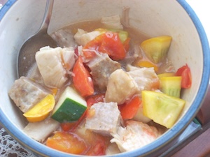A bowl of cooked chopped squash, tomatoes, and meat.