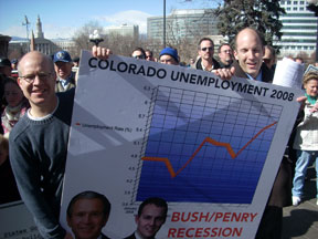 Jason Salzman and Michael Huttner carry a sign showing Colorado unemployment going up in 2008 with the text Bush Penry Recession.