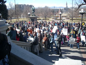 A crowd gathers on the front steps of the Colorado capitol.