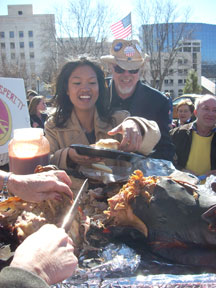 Michelle Malkin next to a roasted pig.