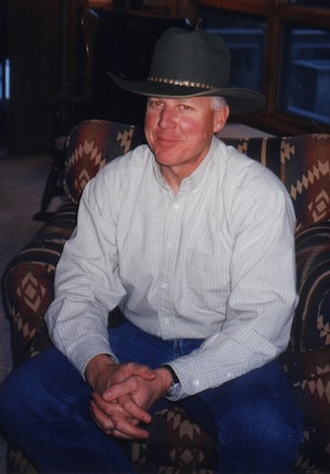 Bill Masters, seated, wearing a cowboy hat.